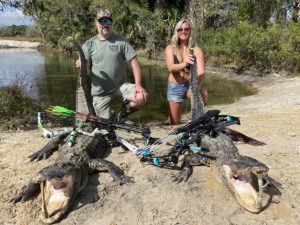 husband and wife showing off their allligators that they caught